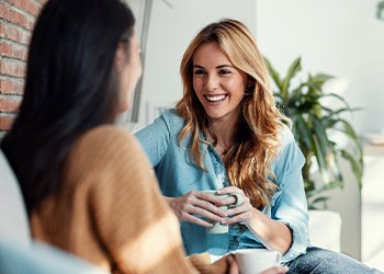 Friends smiling while having coffee together
