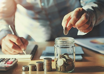 Someone putting coins into a jar