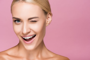 Woman smiling and winking on a pink background