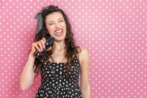 Woman using her teeth to open a soda bottle on pink and white background